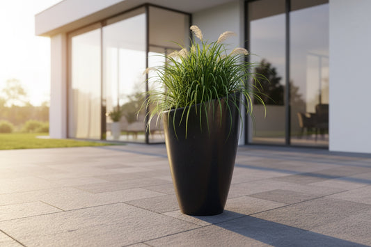 Solen Garden NILA 310 tall black planter with ornamental grass on a modern patio.
