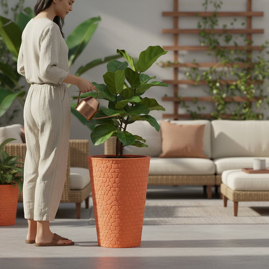 Solen Garden PETRA 100 tall orange planter with textured stone pattern, holding a fiddle leaf fig plant. Woman watering plant on patio.
